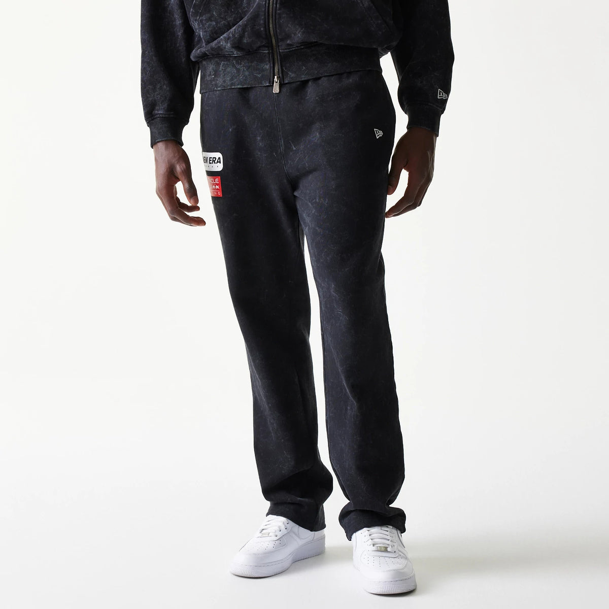 New Era Red Bull Racing Straight Leg Black Straight Leg Joggers, front view on a model showing the New Era patch on the left thigh, a washed effect, and a small embroidered New Era flag logo on the right pocket.