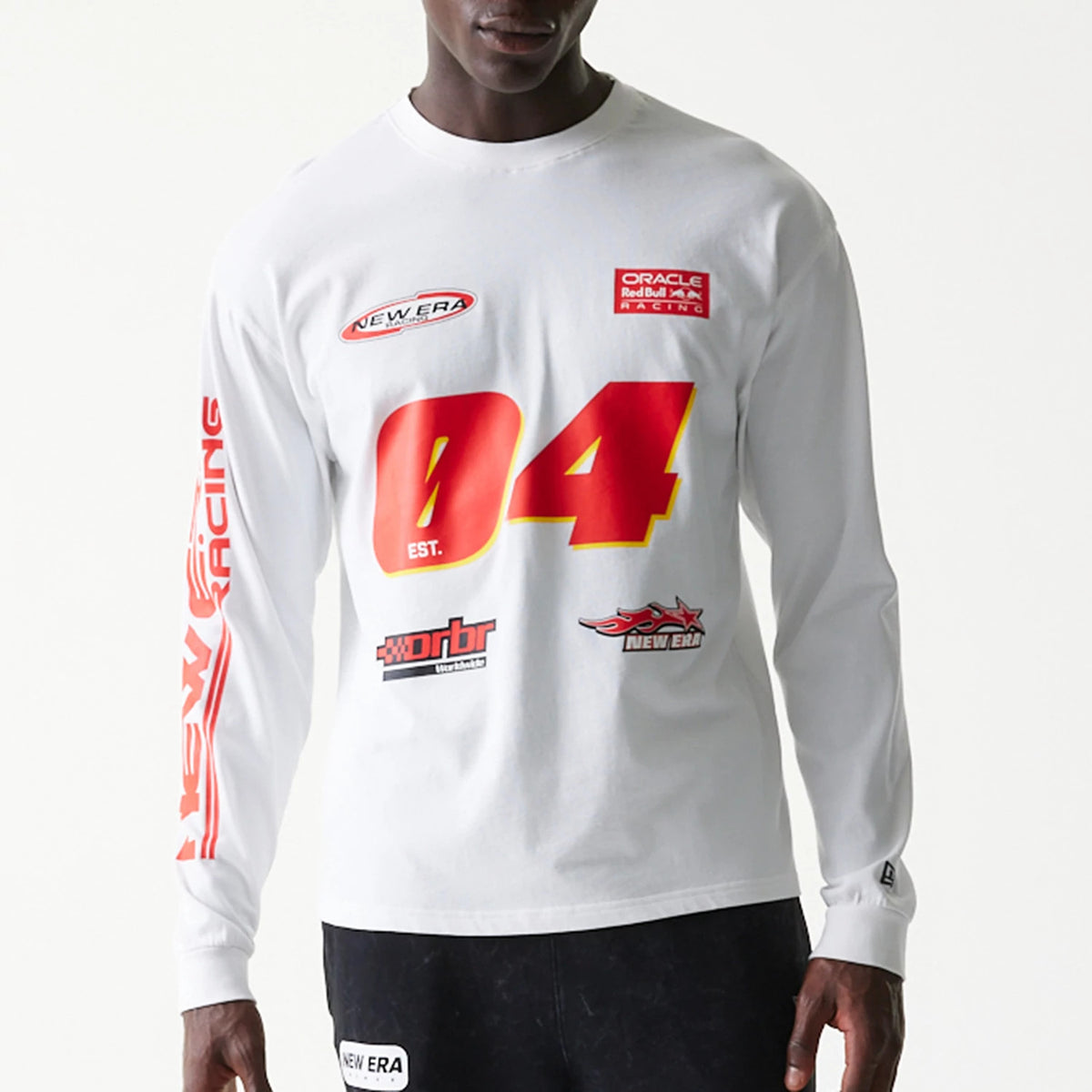 New Era Red Bull Racing Graphic White Long Sleeve T-Shirt, front view on-model showing red 04 text on the chest with multiple logos and racing graphics above and below, New Era red branding on the left sleeve and a small logo on the cuff.