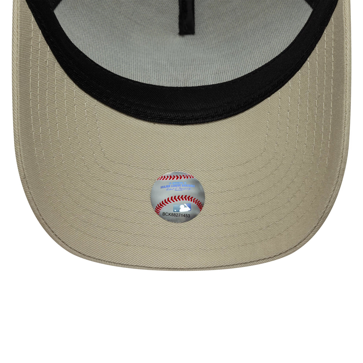 New York Yankees MLB Light Beige New Era 9FORTY A-Frame Trucker Cap, inside view showing a black sweatband, grey undervisor, and a baseball graphic sticker on the light beige curved visor.
