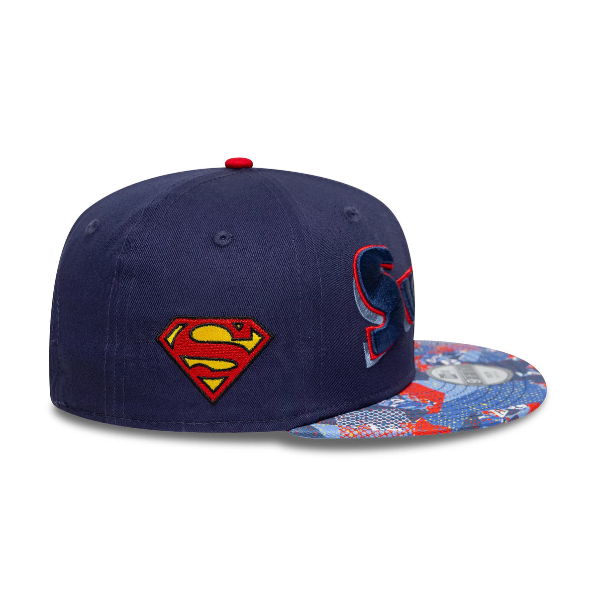 Youth DC Superman Navy New Era 9FIFTY Snapback Cap, side view showing the red and yellow embroidered Superman logo on the navy crown, with a graphic-print visor featuring a 9FIFTY size sticker.