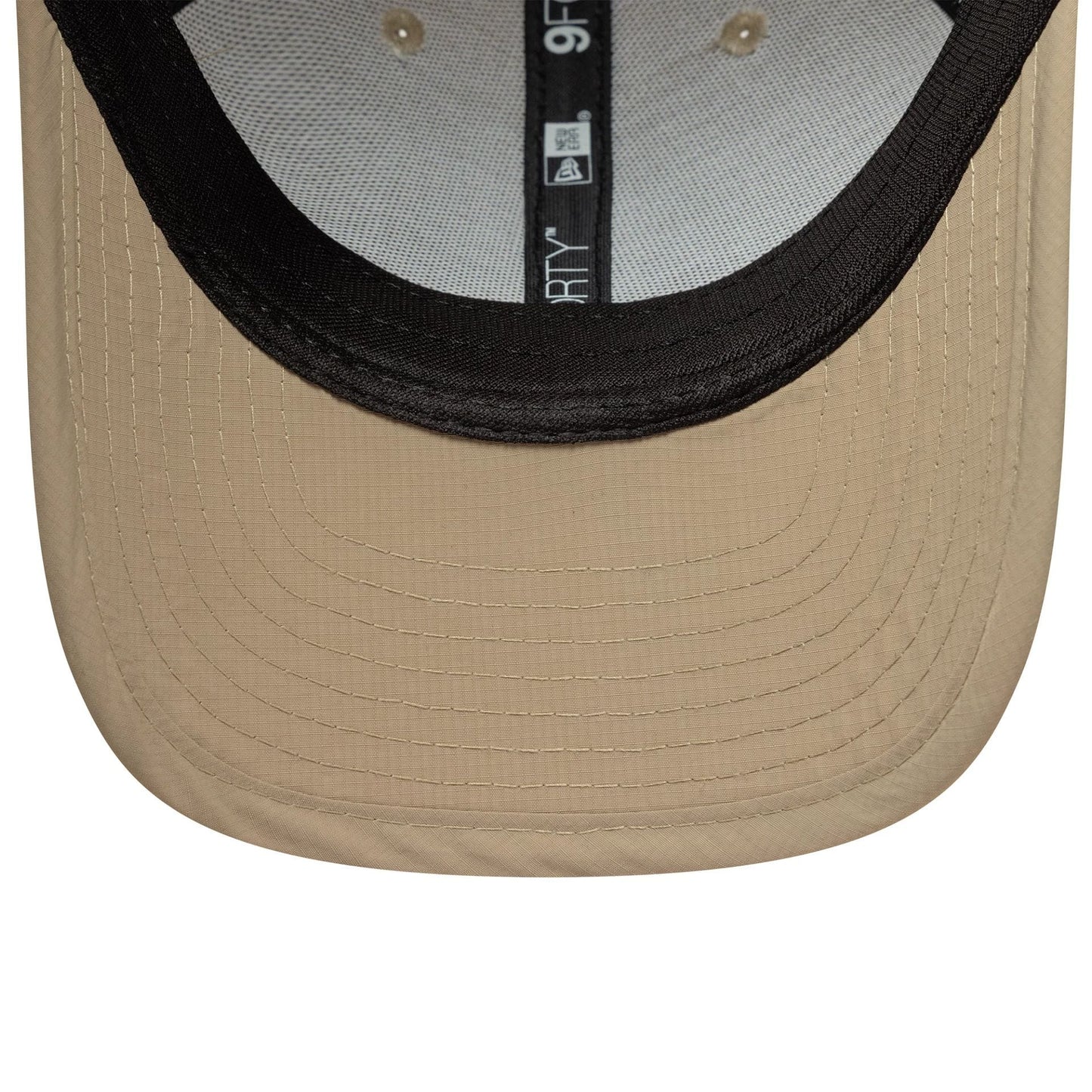 New Era Sport Light Beige 9FORTY M-Crown Cap, inside view showing the black taped seams labelled 9FORTY and New Era along a grey sweatband, set against a beige undervisor with a curved shape and stitching lines.