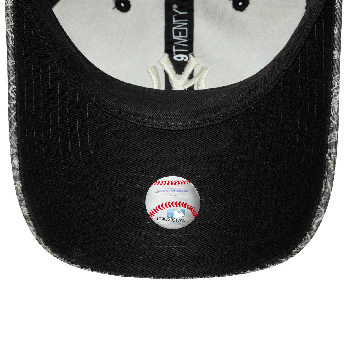 New York Yankees MLB Washed Paisley Black New Era 9TWENTY Cap, inside view showing the grey sweatband and black taping with New Era branding, a white MLB sticker on the black undervisor, and paisley fabric on the edge.