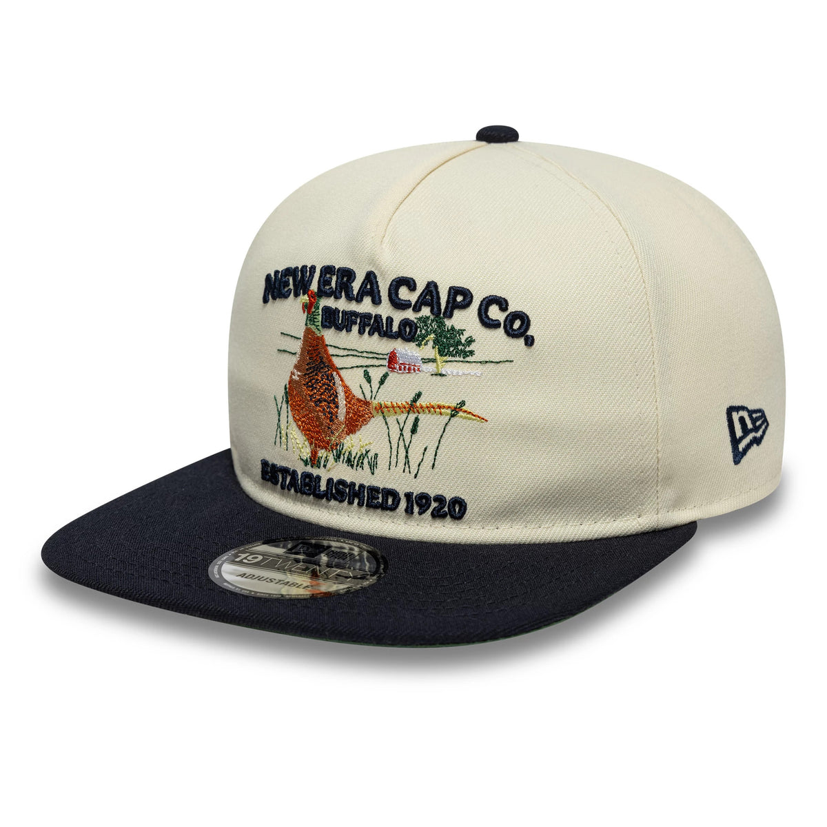 New Era Outdoor Graphic Light Beige New Era 19TWENTY Adjustable Cap, three-quarter view showing a detailed embroidered bird and landscape scene on the structured front panels, with a contrasting black flat visor and a 19TWENTY size sticker.