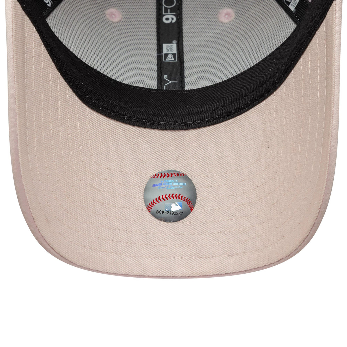 New York Yankees Womens MLB Satin Pastel Pink New Era 9FORTY Cap, inside view showing the grey MLB holographic sticker on the pink undervisor, black sweatband with white 9FORTY lettering, and pink eyelets on the structured crown panels.