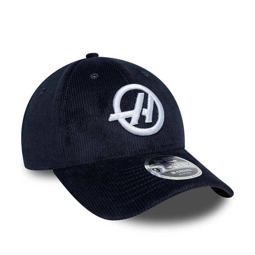 TGR Haas F1 Cord Navy New Era 9FORTY Cap, three-quarter view showing the raised white embroidered team logo on the front panel of the navy corduroy fabric, with a curved visor and 9FORTY size sticker.