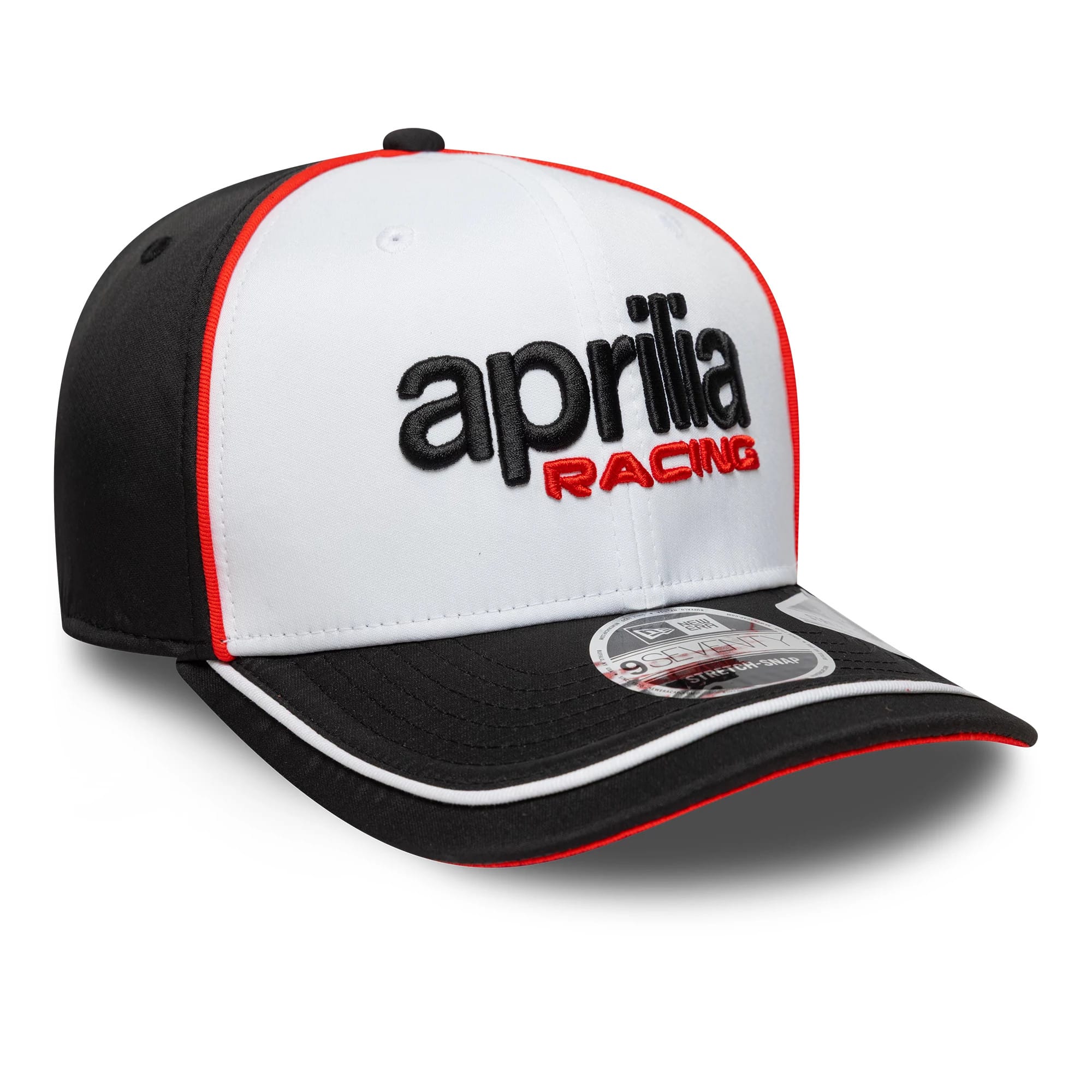 Aprilia Logo White New Era 9SEVENTY Stretch Snap Cap, three-quarter view showing black embroidered aprilia text and red RACING on the white front panel, black visor with red edging, and 9SEVENTY size sticker on the visor.