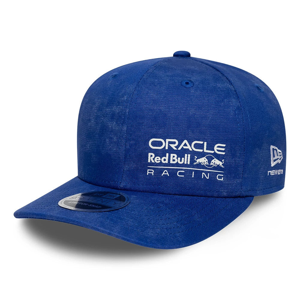 Red Bull Racing Washed Denim Blue New Era 9SEVENTY Stretch Snap Cap, three-quarter view with white embroidered front panel logos, a curved visor featuring a 9SEVENTY size sticker, and the New Era flag logo on the left side.