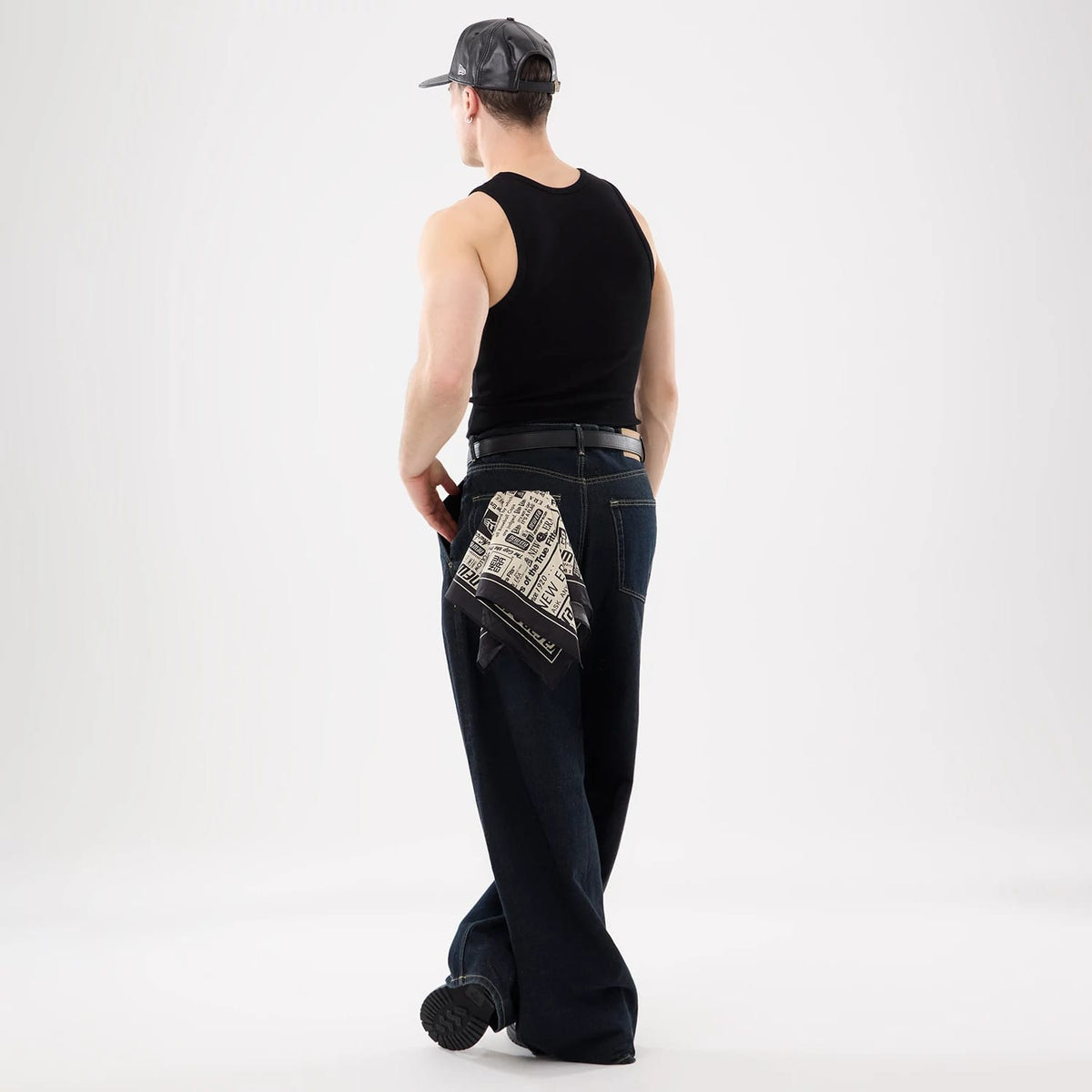 New Era 59FIFTY Day Black Bandana, on-model view showing a casual style with the bandana tucked into the back pocket of relaxed jeans and paired with a black sleeveless top, highlighting the monochrome design.