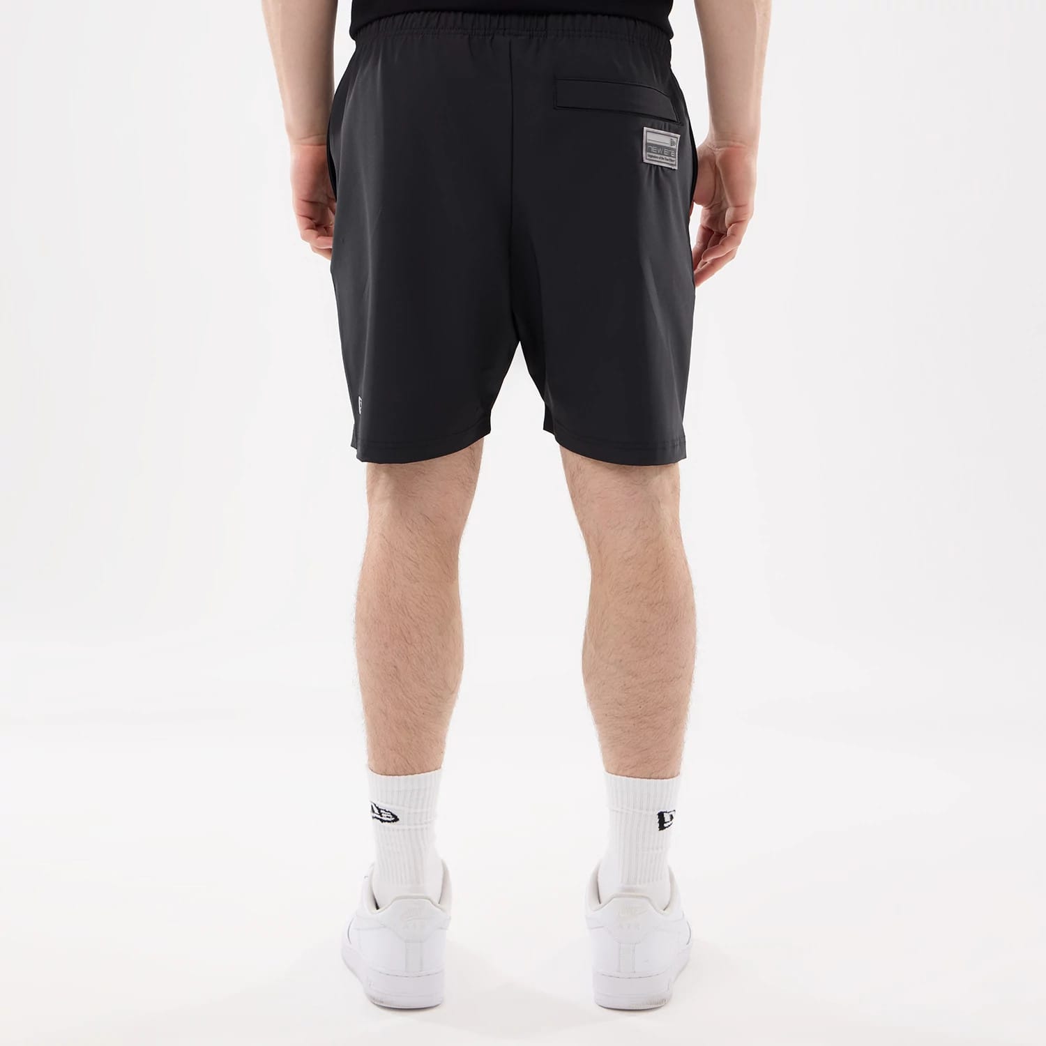 New Era Las Vegas Raiders NFL Match Black Oversized Shorts, back view showing a single pocket with a rectangular patch near the top right and the New Era logo embroidered at the bottom left edge on the black fabric.