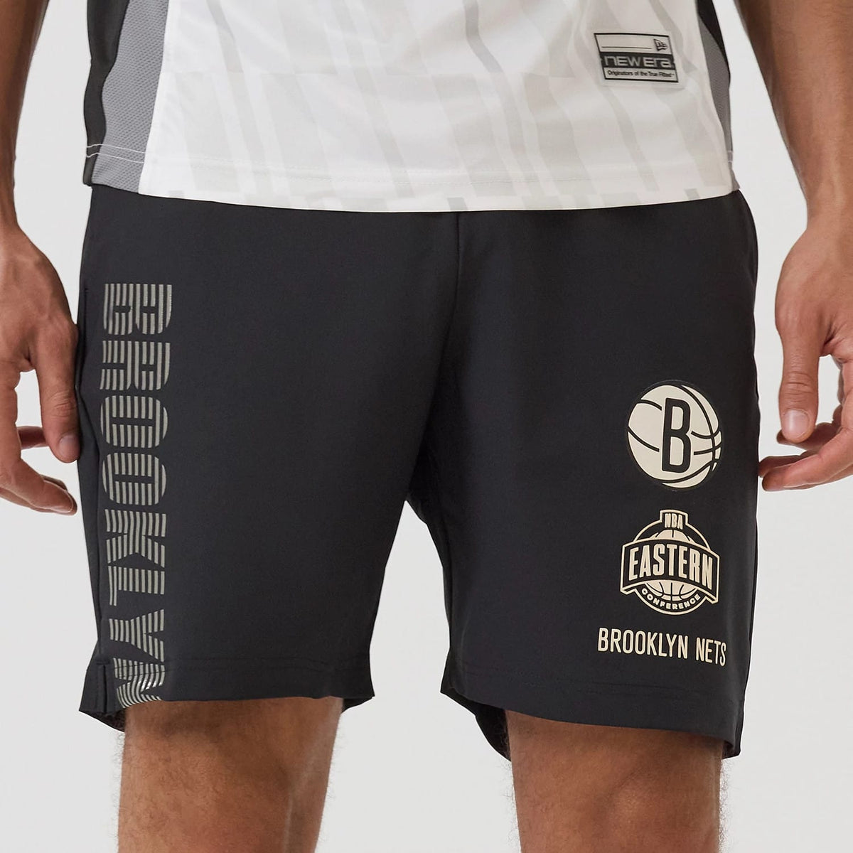 New Era Brooklyn Nets NBA Match Black Oversized Shorts, front view showing large printed Brooklyn lettering down the right leg and two logos on the left leg, including a basketball emblem and Eastern Conference with Brooklyn Nets text.