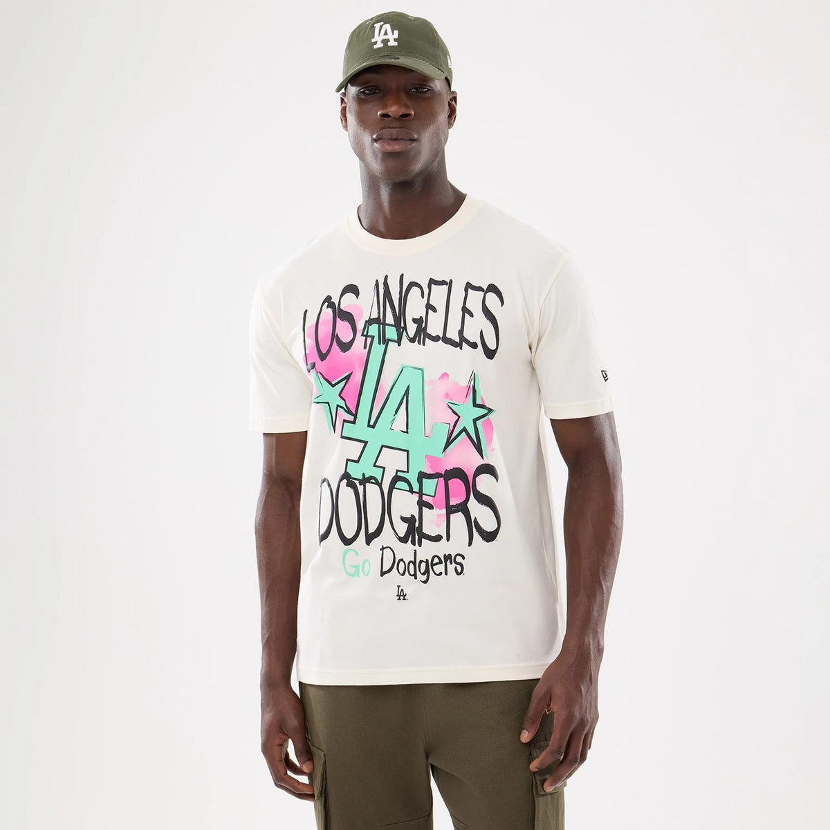 New Era LA Dodgers MLB Street Art Graphic Light Beige T-Shirt, front view on-model showing the Los Angeles Dodgers lettering with green and pink highlights and stars, a small embroidered New Era logo on the left sleeve.