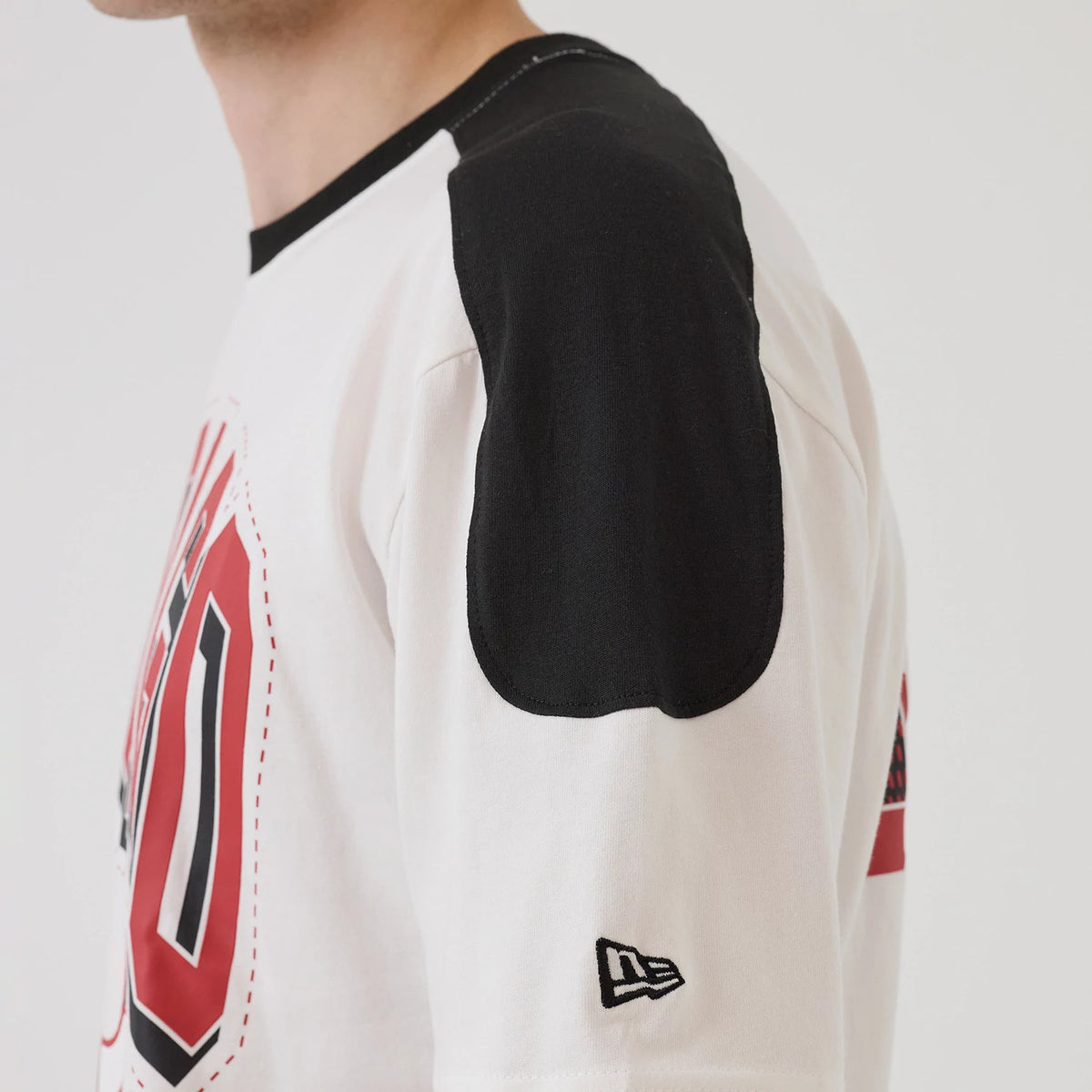 New Era Chicago Bulls NBA Sport Classic White T-Shirt, side view showing black shoulder panel, large red and black graphic on the chest, and a black embroidered New Era logo on the lower sleeve.