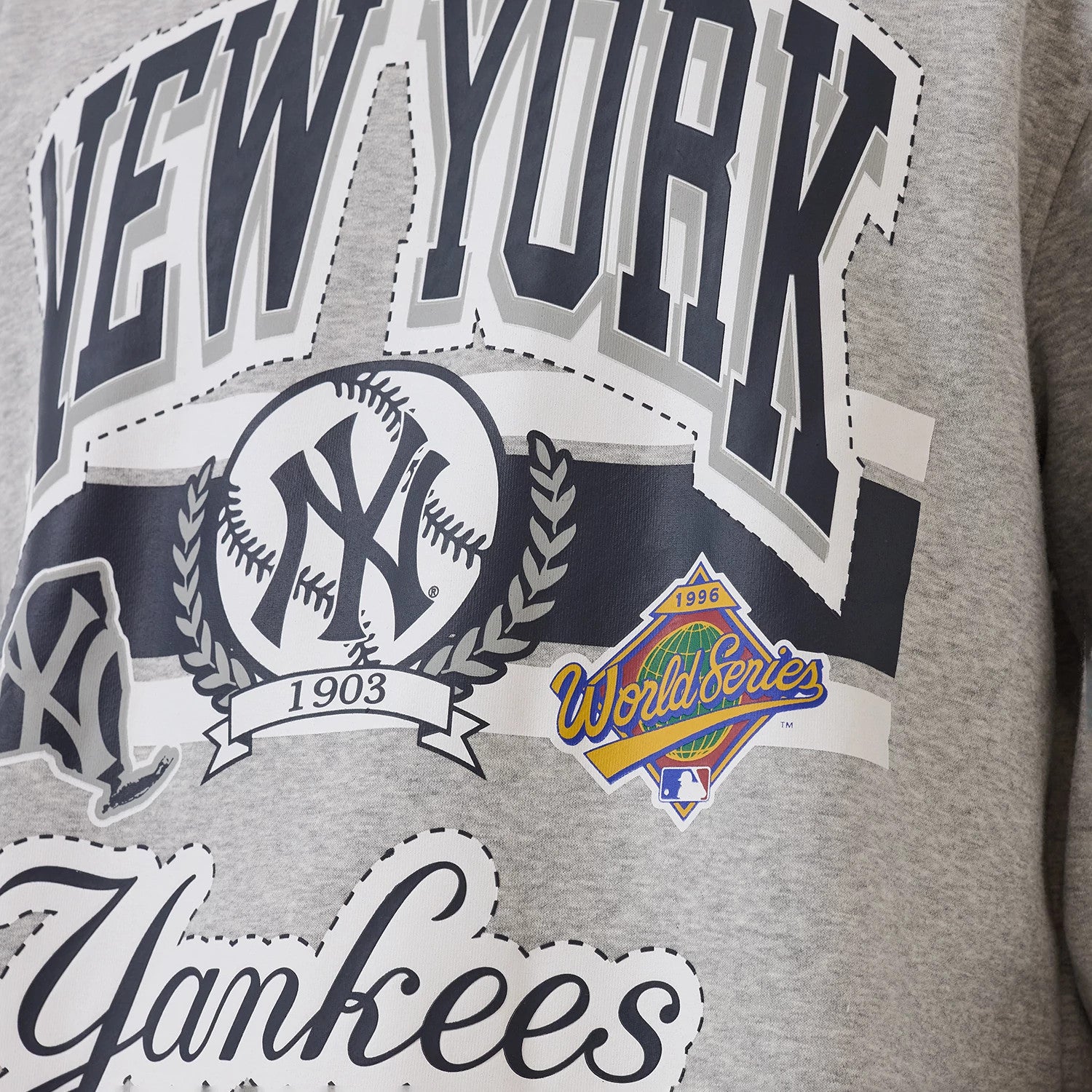New Era New York Yankees MLB Sport Classic Grey Crew Neck Sweater, close-up view showing the large printed New York lettering across the chest with a baseball logo, 1903 banner, and a 1996 World Series graphic detail.