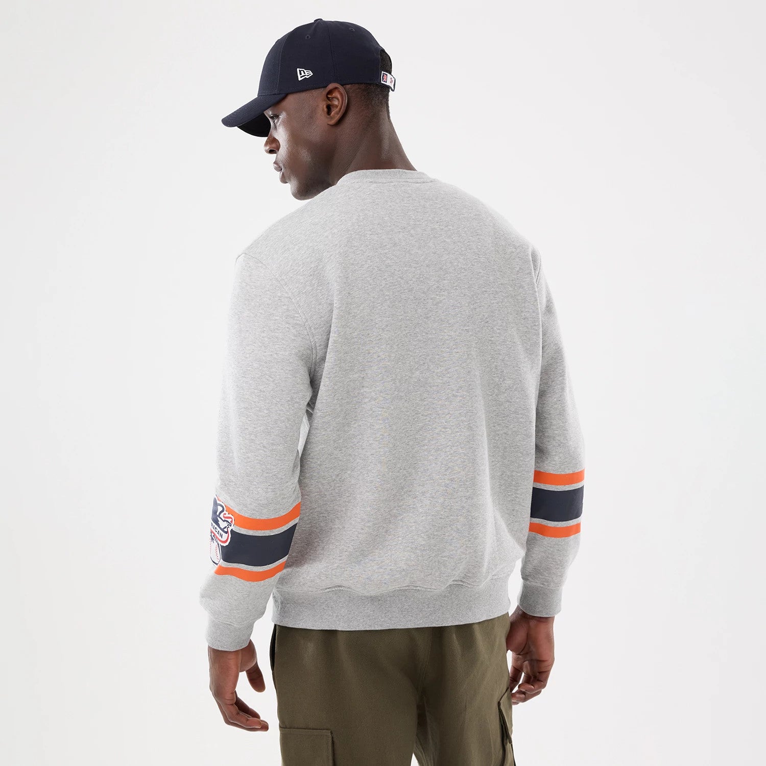 New Era Detroit Tigers MLB Sport Classic Grey Crew Neck Sweater, back view on a model with a navy cap, showing the grey fabric with Detroit Tigers logo and orange and navy stripes on the sleeves.