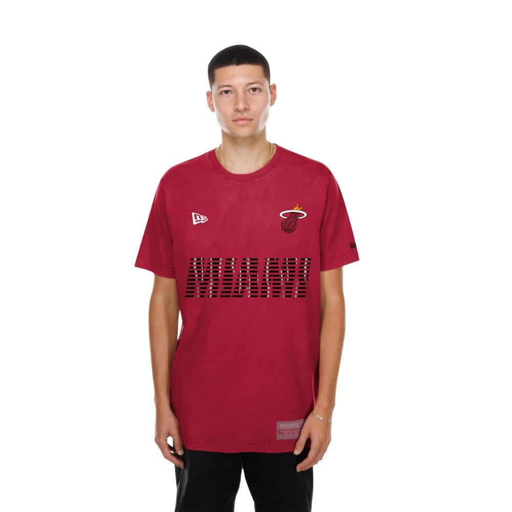New Era Miami Heat NBA Match Dark Red T-Shirt, front view on a model featuring the printed Miami Heat logo on the chest, an embroidered New Era logo on the left side, and horizontal striped lettering across the front.