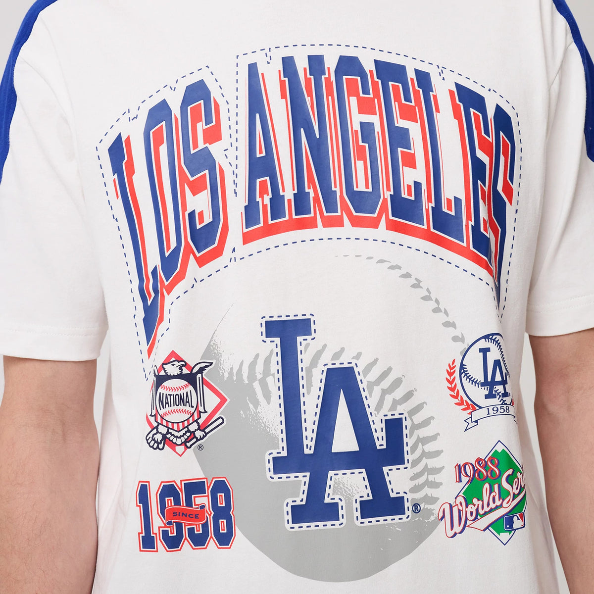 New Era LA Dodgers MLB Sport Classic White T-Shirt, back view showing the blue and red Los Angeles lettering above a large blue LA logo with baseball graphics and emblems, including World Series and 1958 details.