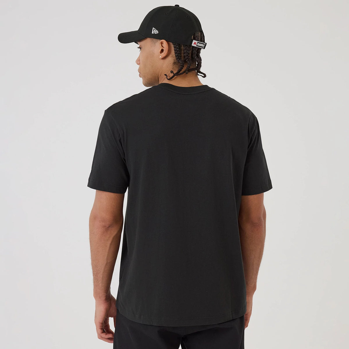 New Era Las Vegas Raiders NFL Sport Classic Black T-Shirt, back view on-model paired with a cap, showing a clean black surface with no graphics or logos on the rear of the T-shirt.