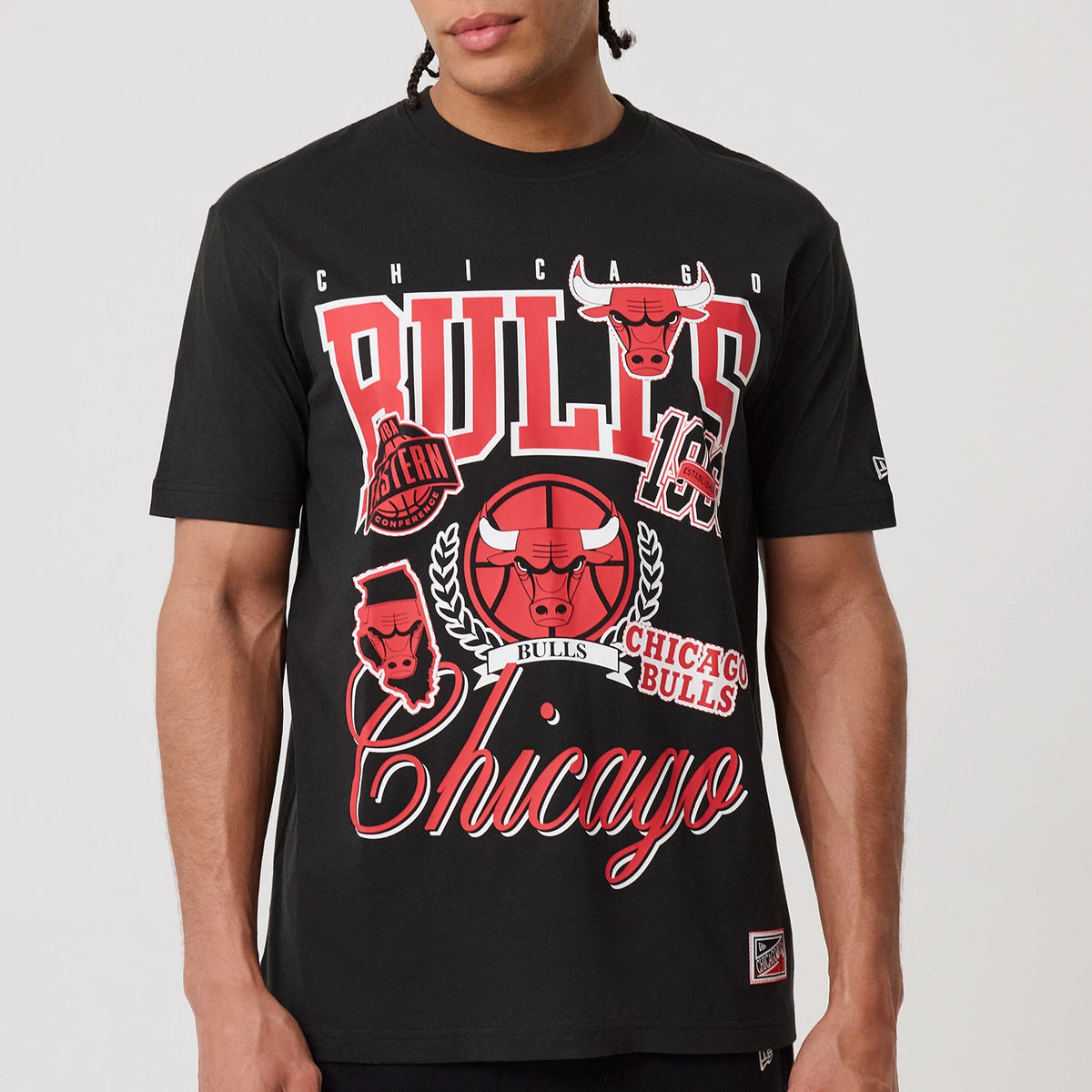 New Era Chicago Bulls NBA Sport Classic Black T-Shirt, front view on-model featuring a red and white graphic with the Bulls logo and Chicago lettering, with a small embroidered New Era logo on the left sleeve.