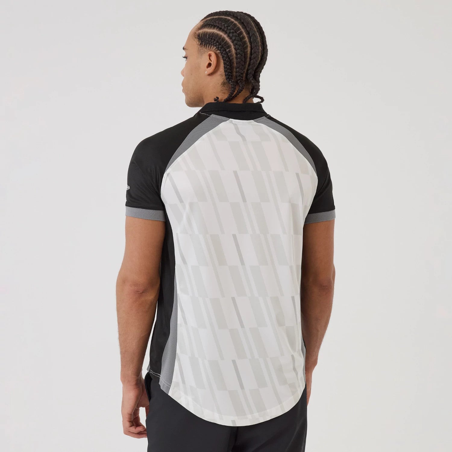 New Era Brooklyn Nets NBA Match Black T-Shirt, back view on-model showcasing the white mesh panel with a geometric pattern, black sleeves with grey trim, and an embroidered New Era logo on the left sleeve.