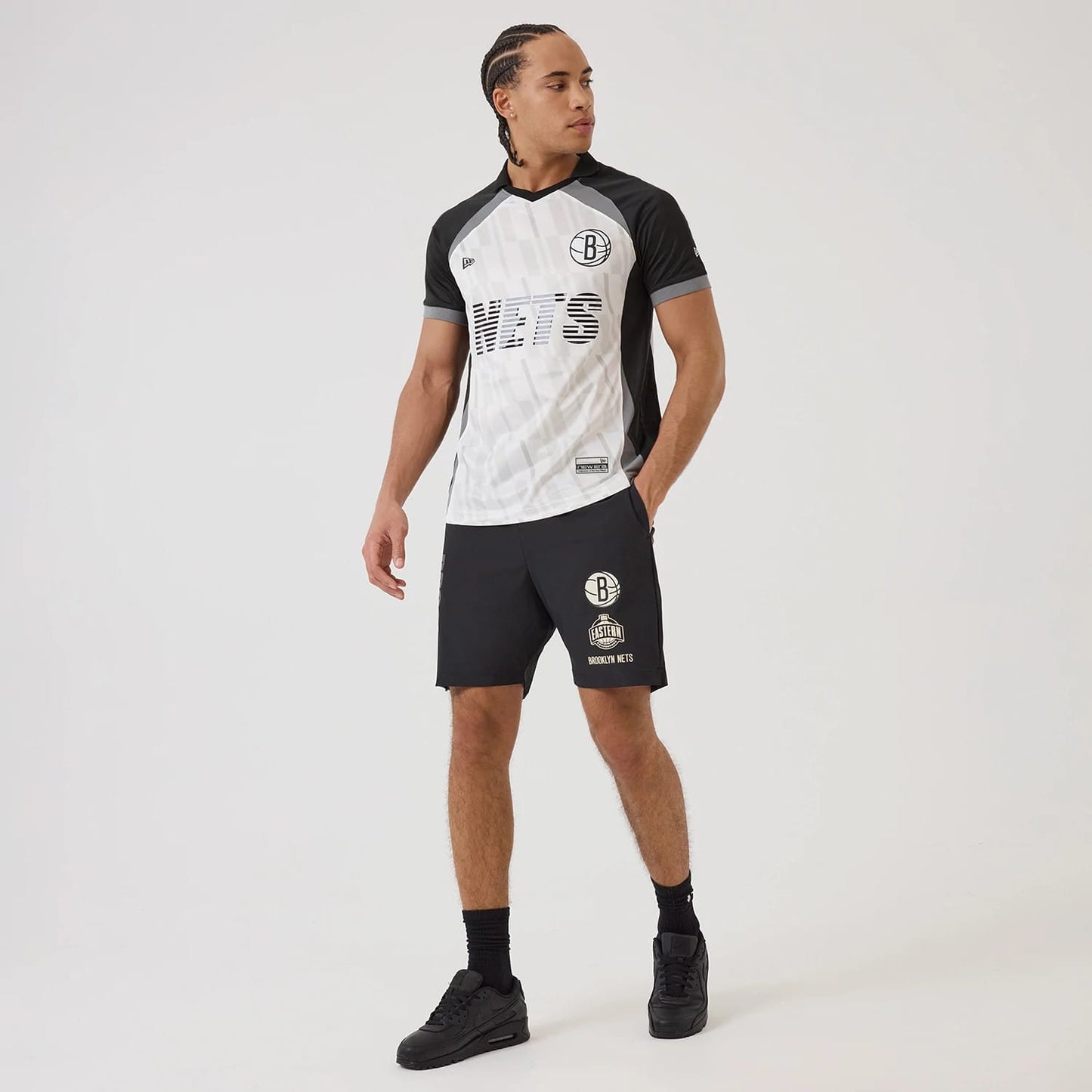 New Era Brooklyn Nets NBA Match Black T-Shirt, front view on-model displaying the black and white design with an embroidered Nets logo on the left chest, striped lettering across the front, and contrasting black sleeves.