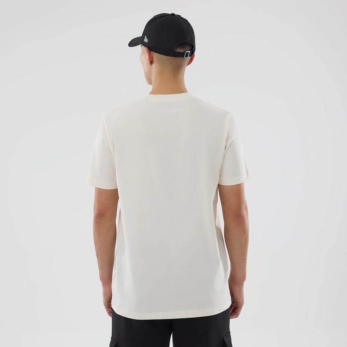 New Era Cactus League Logo MLB Spring Training 2026 Cream T-Shirt, back view on a model with a black cap, showing a plain cream back without graphics or text, emphasising the simple and clean design of the garment.