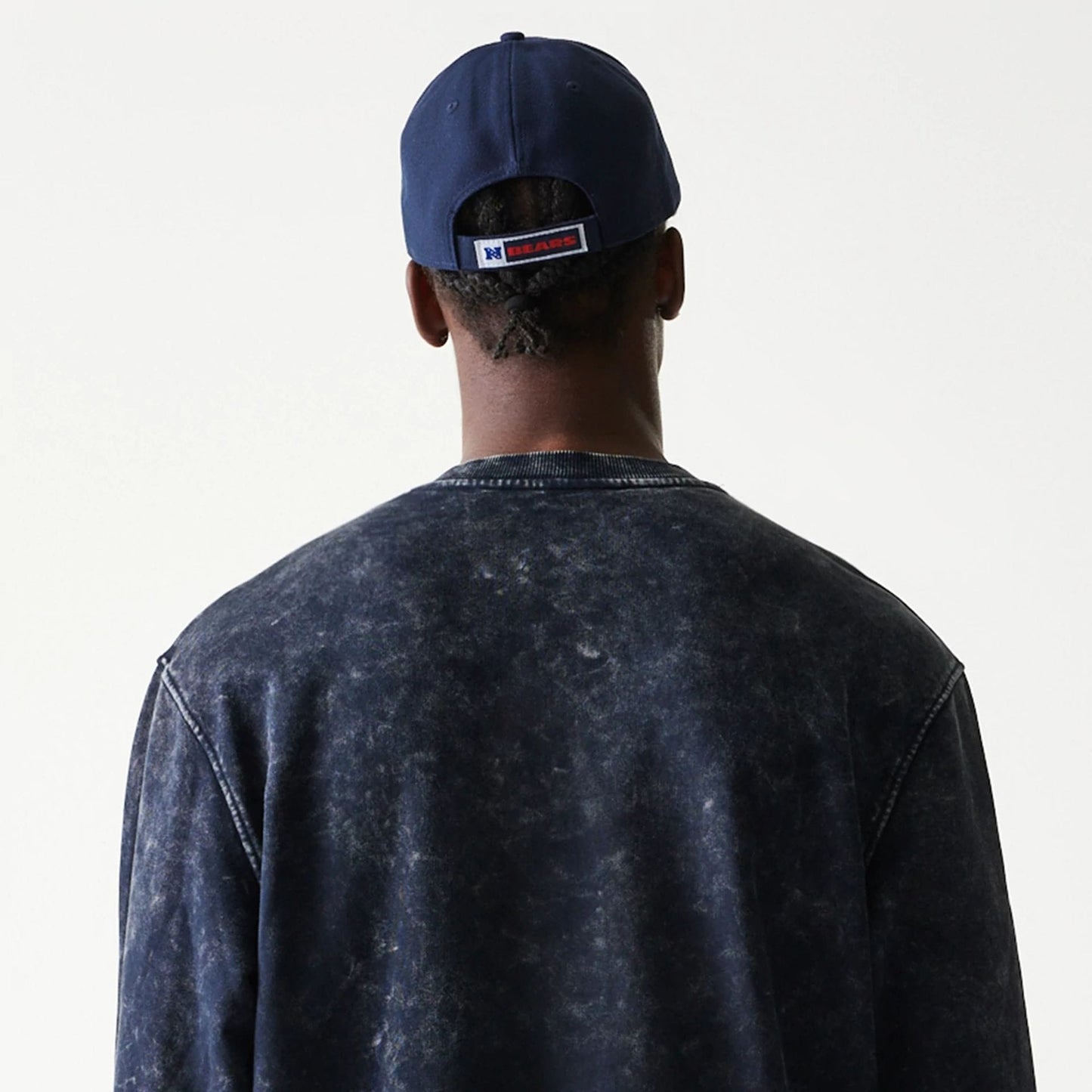 New Era Chicago Bears NFL Navy Crew Neck Sweater, rear view on a model wearing a matching navy cap, showing the washed navy fabric and ribbed neck detail with stitching along the shoulders.