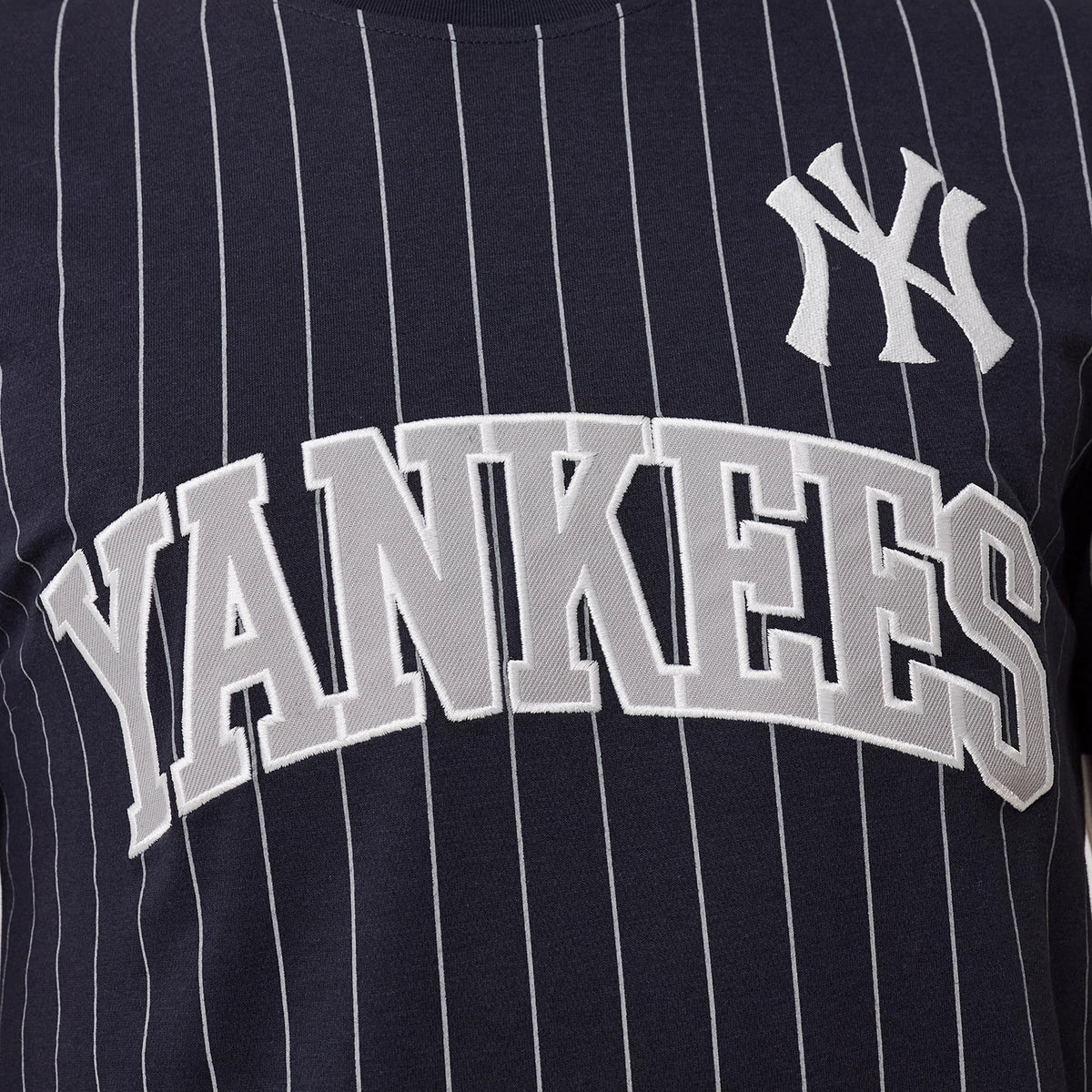 New Era New York Yankees MLB Pinstripe Navy T-Shirt, front view displaying vertical pinstripes, a large raised Yankees wordmark across the chest, and a smaller raised New York Yankees logo on the upper left side.