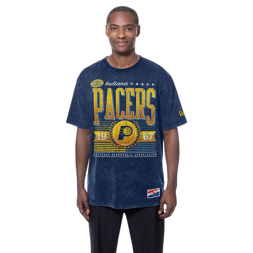 New Era Indiana Pacers NBA Anniversary Navy T-Shirt, front view on-model featuring a large printed PACERS graphic in yellow and gold across the chest, with a smaller New Era logo on the left sleeve and a patch near the bottom hem.