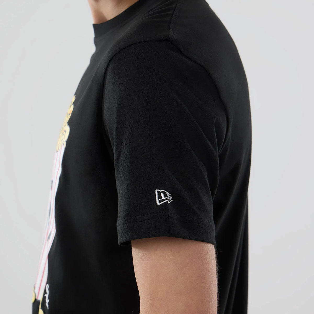 New Era Chicago White Sox MLB Popcorn Black T-Shirt, side view showing a graphic with yellow popcorn on the chest, a white embroidered New Era logo on the left sleeve, and the sleeve ending just above the elbow.