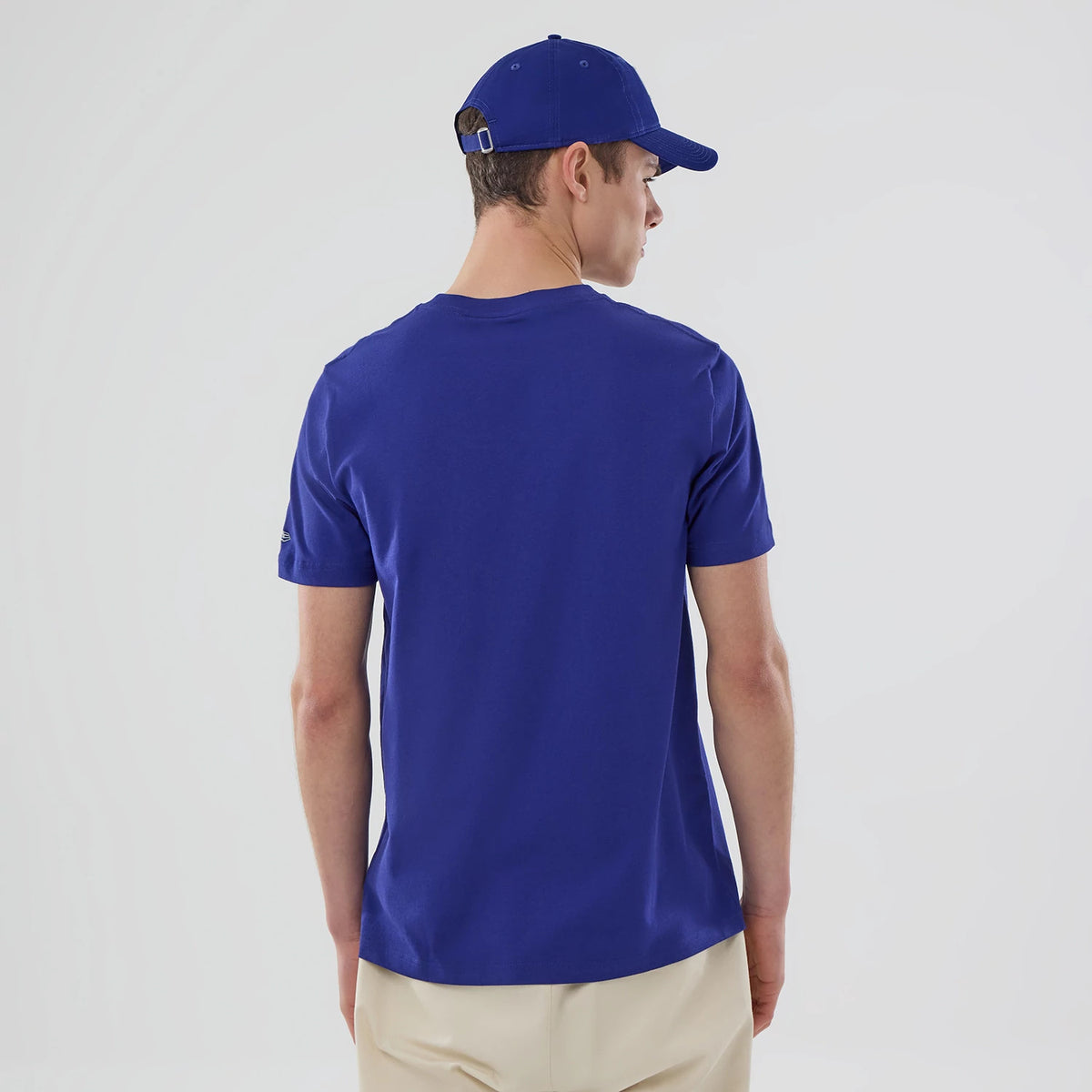 New Era LA Dodgers MLB Popcorn Dark Blue T-Shirt, back view on a model styled with a cap, showcasing the plain dark blue fabric and a short sleeve design with a small printed logo on the right sleeve.