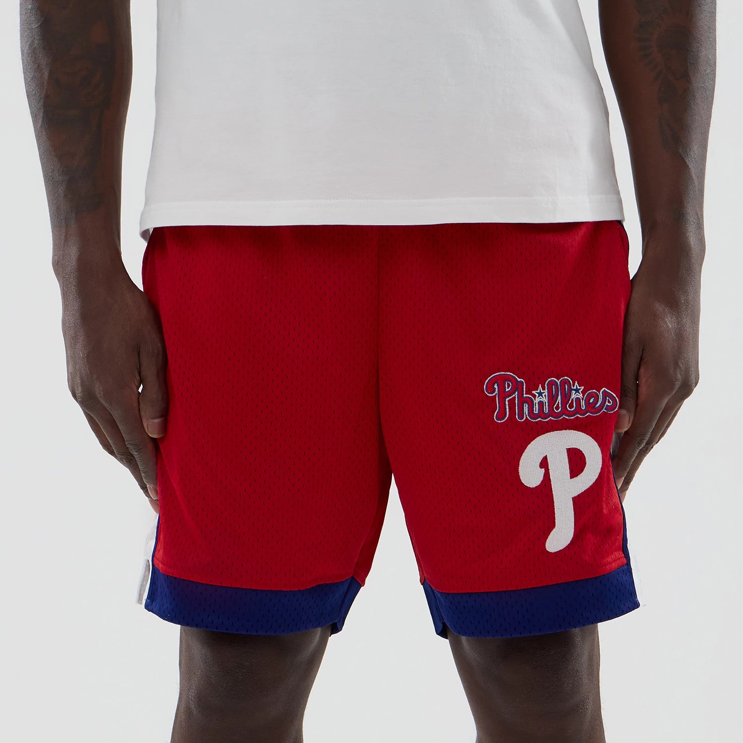 New Era Philadelphia Phillies MLB Red Mesh Shorts, front view showing the red fabric with contrasting blue trim, featuring an embroidered Phillies logo on the left leg with 'Phillies' in white outlined lettering and a large P below.