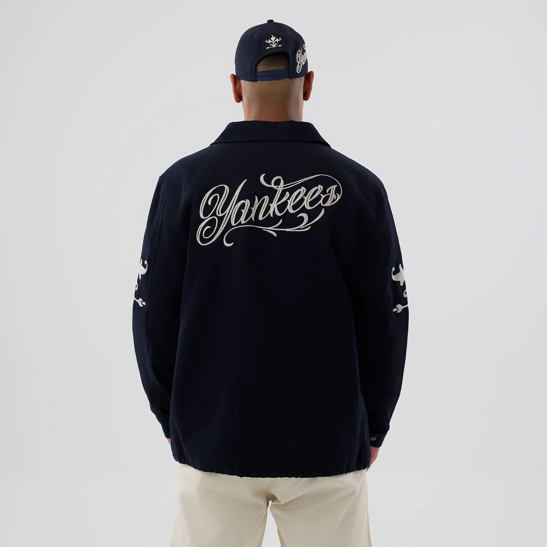 The model is wearing this MLB Script New York Yankees Coach Jacket in navy. 2