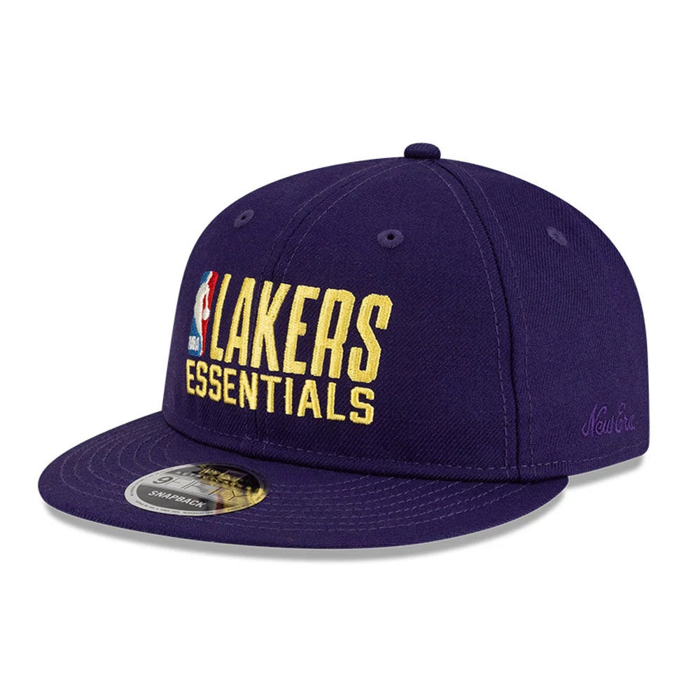 LA Lakers FOG x NBA Dark Purple Retro Crown New Era 9FIFTY Adjustable Cap, three-quarter view showing the yellow Lakers Essentials logo in raised embroidery on the front panel, with the NBA logo, flat visor and a 9FIFTY size sticker.