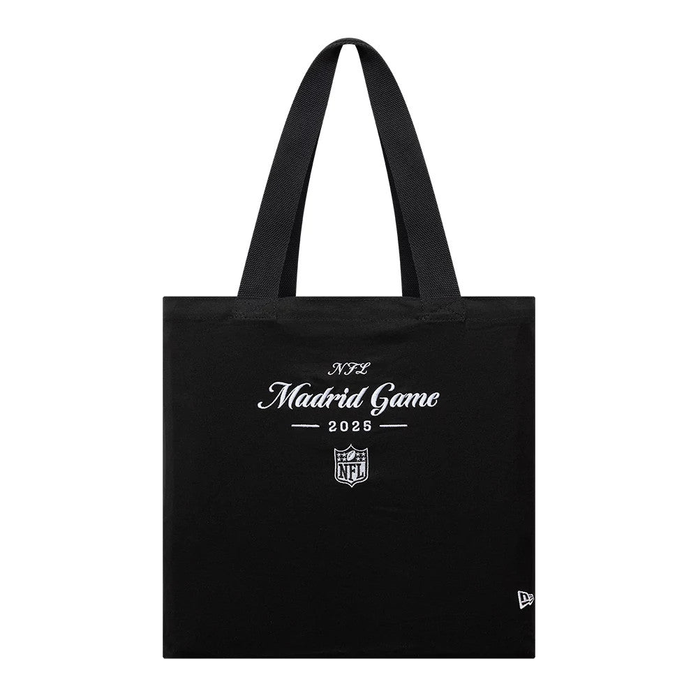 New Era Shield Logo NFL Madrid Game 2025 Black Tote Bag, front view showing white embroidered lettering NFL Madrid Game 2025 and an NFL shield logo beneath, with short black handles above and a small New Era logo at the bottom corner.