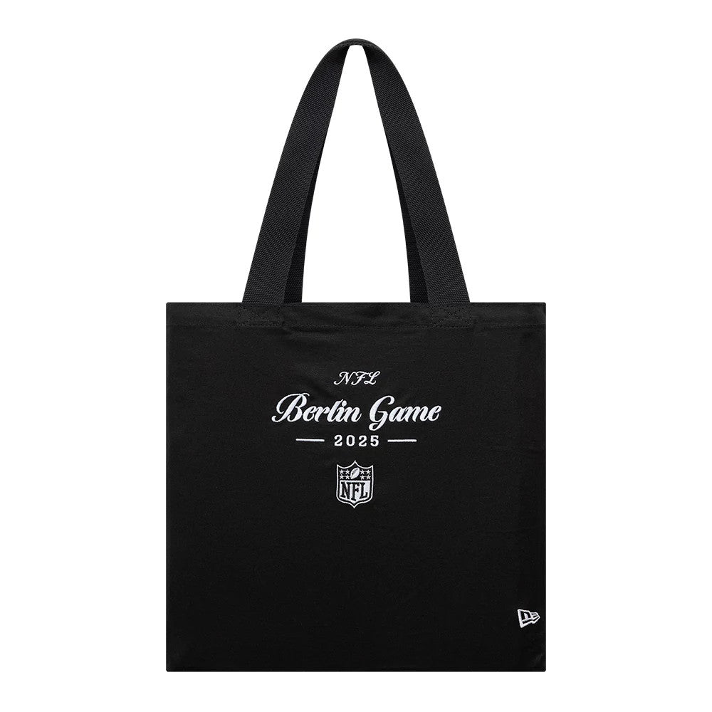 New Era Shield Logo NFL Berlin Game 2025 Black Tote Bag, front view displaying the white embroidered Berlin Game 2025 lettering and NFL shield logo centred on the black fabric, with two handles.
