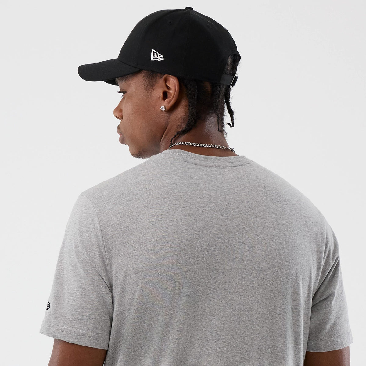 New Era Back To School Grey T-Shirt, back view showing the plain grey fabric extending over the shoulders and down the back, with a small embroidered New Era logo on the left sleeve near the hem.