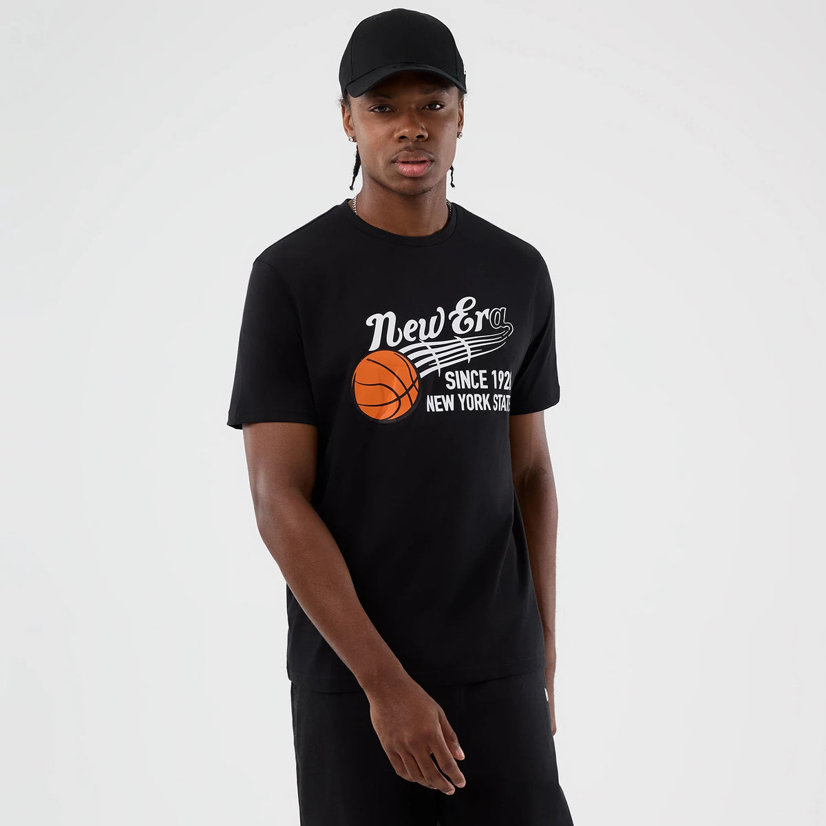 New Era Back To School Black T-Shirt, front view on-model showing a printed New Era script logo and basketball graphic across the chest, along with the words Since 1920 and New York State in white on a solid black background.