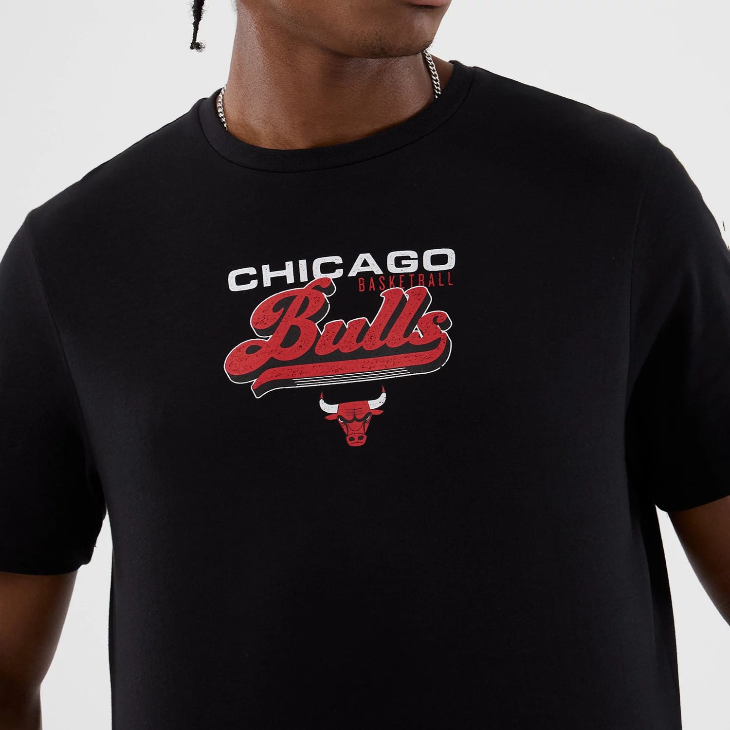 New Era Chicago Bulls NBA Back To School Black T-Shirt, front view showing the red Bulls script logo with a white outline and the red bull head beneath, printed centrally on the chest against the solid black fabric.