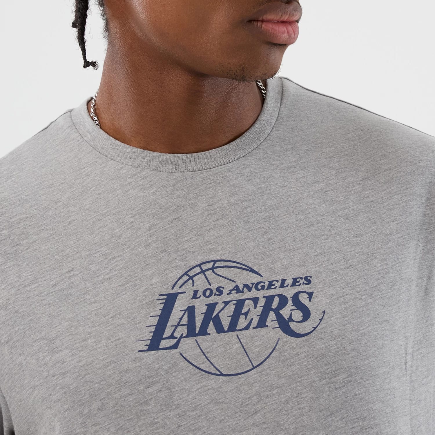 New Era LA Lakers NBA Back To School Grey T-Shirt, front view on a model showing a blue printed Los Angeles Lakers logo with a basketball graphic on the chest, styled simply with a necklace.