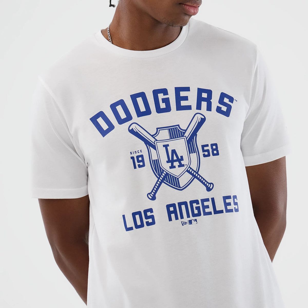 New Era LA Dodgers MLB Back To School White T-Shirt, front view on-model showing a large blue printed Dodgers logo with crossed bats, Los Angeles text, and the year 1958 centred on the chest.