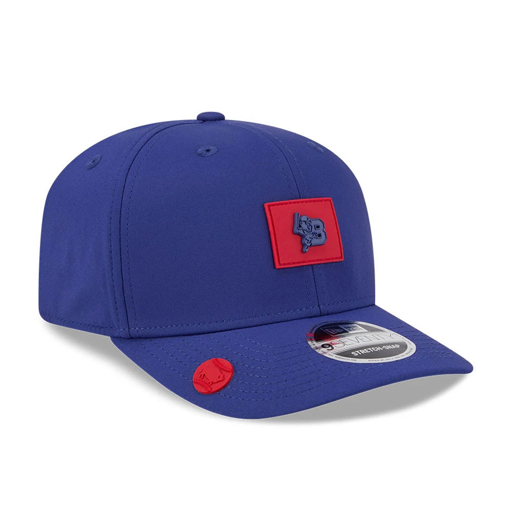 Buffalo Bisons MiLB Clubhouse Dark Blue New Era 9SEVENTY Stretch Snap Adjustable Cap, three-quarter view showing the raised blue logo on a red patch on the front panel, curved blue visor with a 9SEVENTY size sticker and a red accent near the visor.