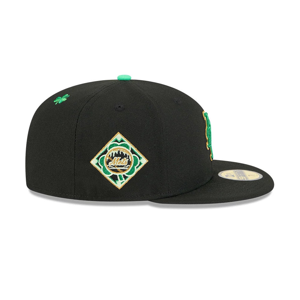 New York Mets MLB Saint Patrick's Day Black New Era 59FIFTY Fitted Cap, side view showing a diamond-shaped Mets logo on the side panel with green and gold embroidery, a green top button, and a gold 59FIFTY size sticker on the flat visor.