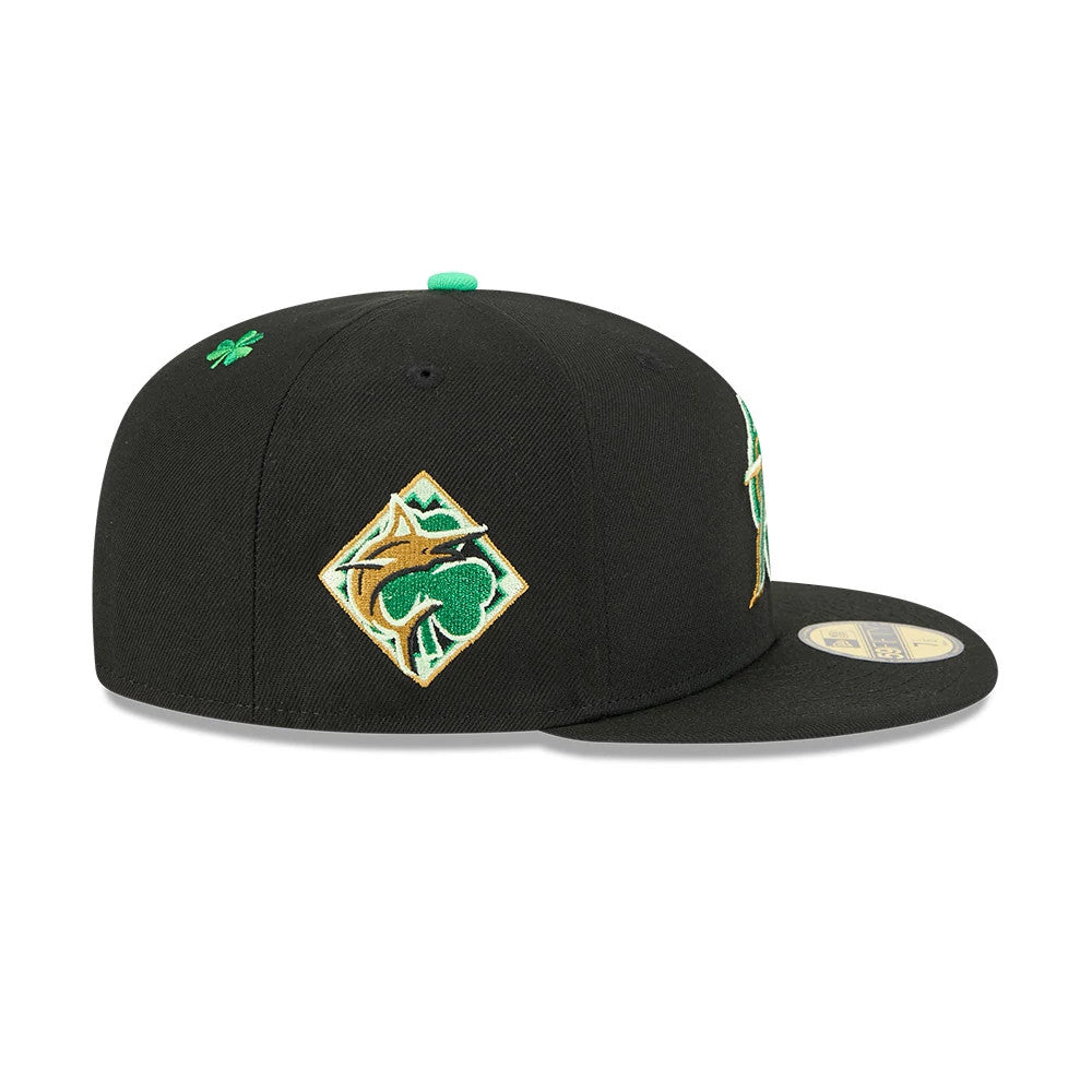 Miami Marlins MLB Saint Patrick's Day Black New Era 59FIFTY Fitted Cap, side view showing a green and gold embroidered logo on the right panel, a small green shamrock above, and a flat black visor with a gold 59FIFTY size sticker.