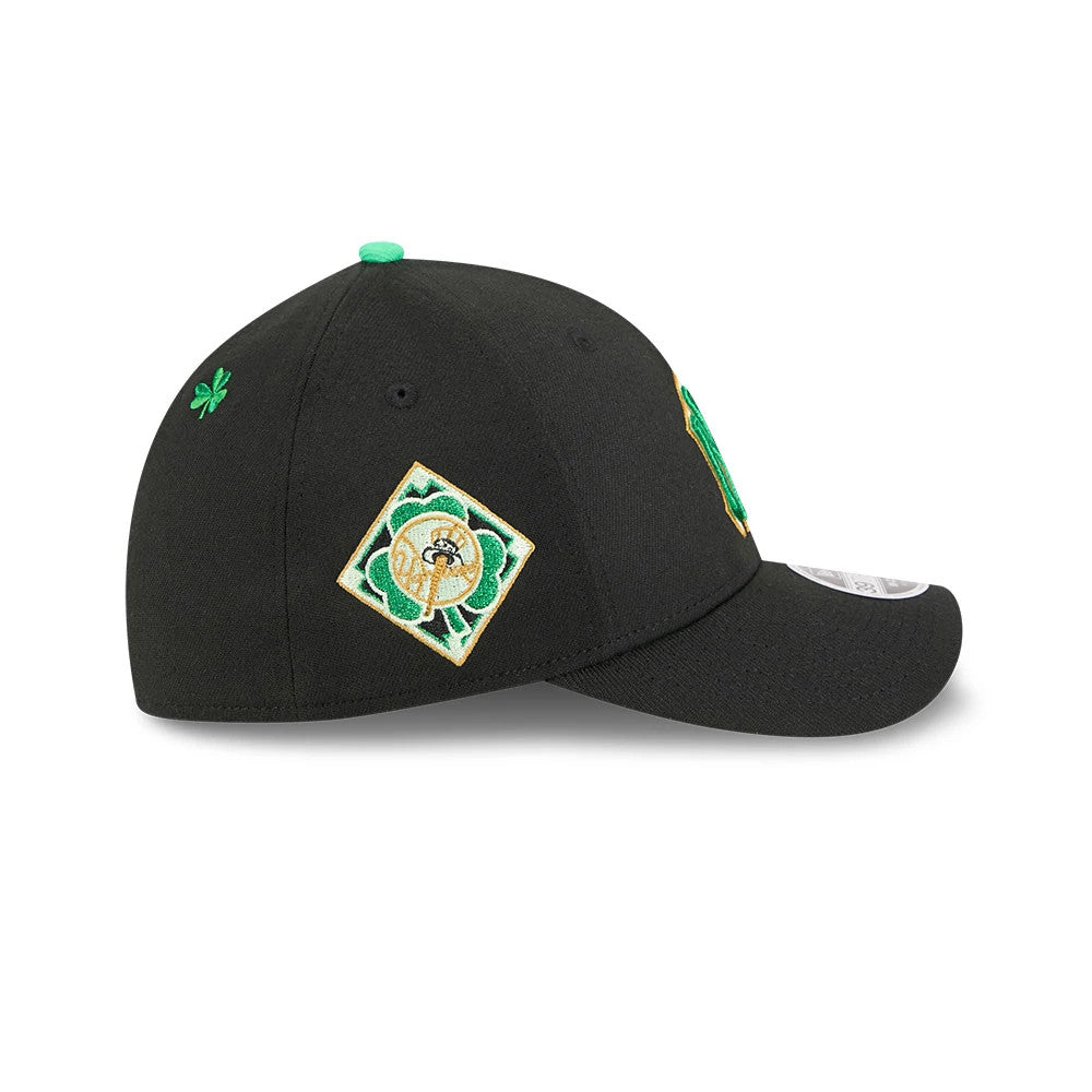 Yankees MLB Saint Patrick's Day Black New Era 39THIRTY M-Crown A-Frame Stretch Fit Cap, side view featuring a clover on the right panel, a square green and gold logo on the left panel, and a curved black visor with a 39THIRTY size sticker.