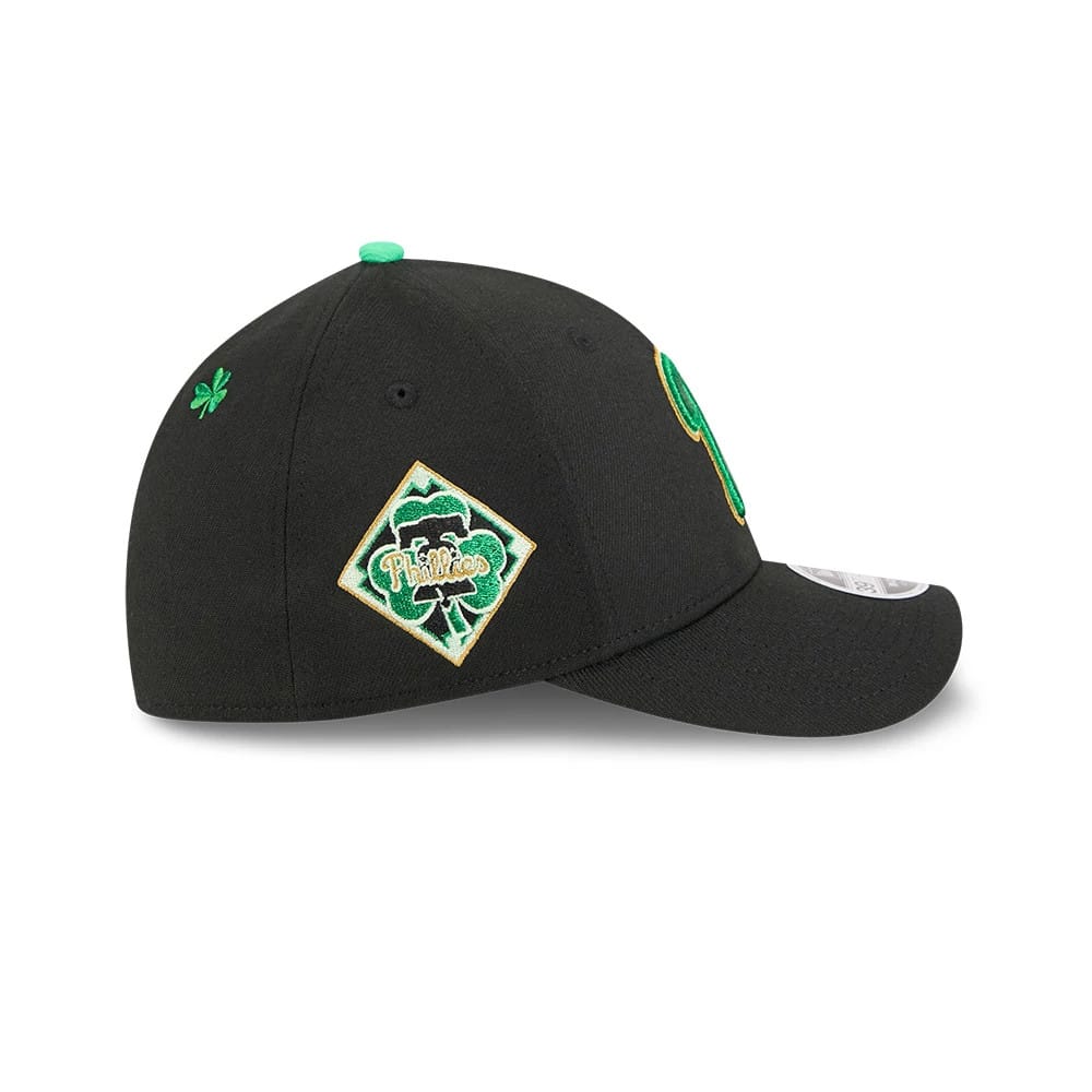 Phillies MLB Saint Patrick's Day Black New Era 39THIRTY M-Crown A-Frame Stretch Fit Cap, side view with a green clover embroidered on the left side, a Phillies diamond patch on the structured crown and a black curved visor.