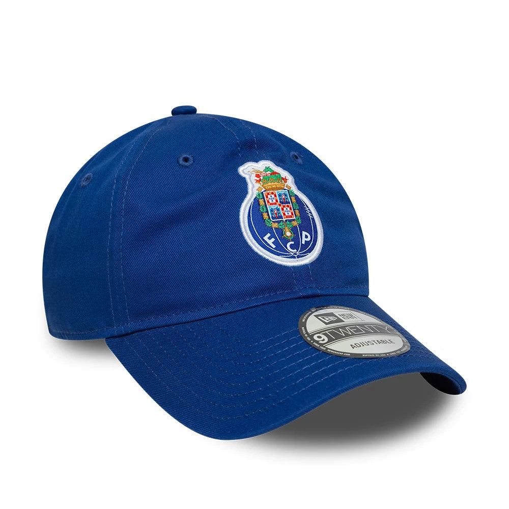 FC Porto Core Blue New Era 9TWENTY Cap, three-quarter view showing the vivid multicolour embroidered club crest prominently on the front panel, with a curved blue visor and a 9TWENTY size sticker above the visor.