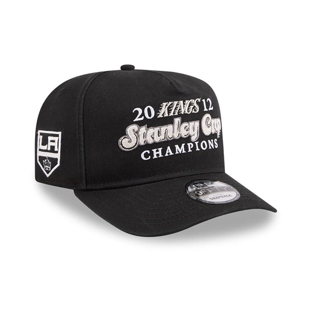 LA Kings NHL Historic Black New Era 9FIFTY A-Frame Snapback Adjustable Cap, front view showing grey embroidered Stanley Cup Champions lettering across the front panels and LA logo on the left side, with a black visor and 9FIFTY size sticker.