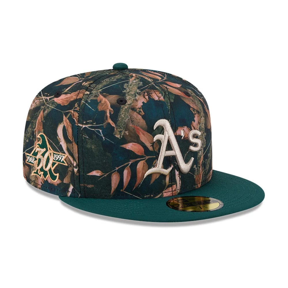 Athletics MLB Leaves Dark Green New Era 59FIFTY Fitted Cap, three-quarter view showing the white embroidered A's logo on the camouflage front panel, dark green flat visor and a gold 59FIFTY size sticker on the top.