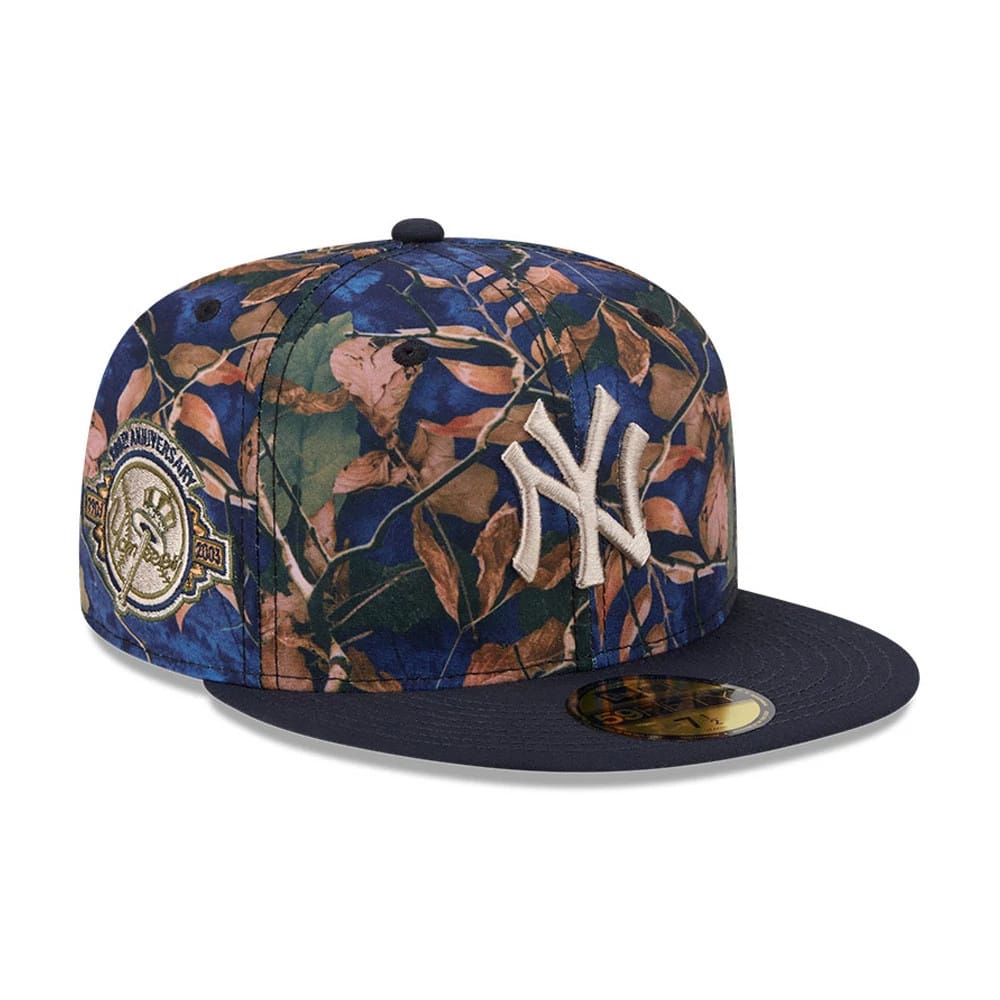 New York Yankees MLB Leaves Navy New Era 59FIFTY Fitted Cap, three-quarter view showing raised NY logo in white embroidery on a leaf-patterned crown, navy flat visor with gold 59FIFTY size sticker, and a commemorative patch on the side.