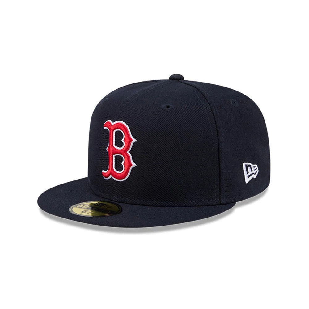 Boston Red Sox MLB Hidden Hit Navy New Era 59FIFTY Fitted Cap, three-quarter view showing the red embroidered B logo on the front panel, a gold 59FIFTY size sticker on the flat navy visor, and the white New Era flag logo on the left side.